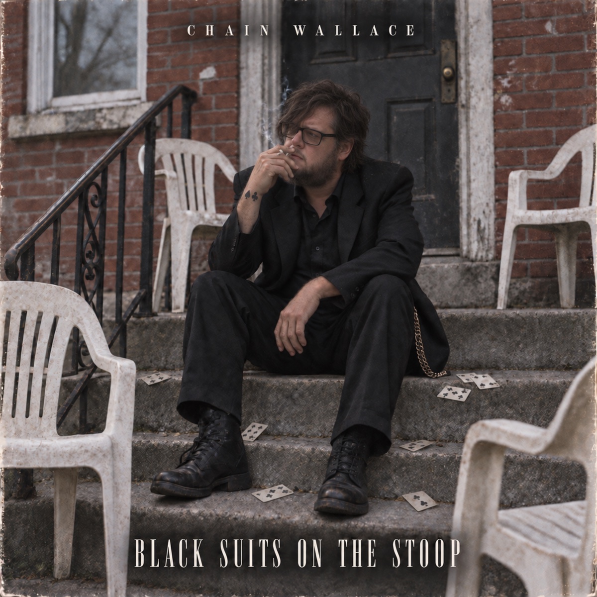 Black Suits on the Stoop album cover: Chain Wallace sits on worn brick steps in a black suit, surrounded by empty chairs