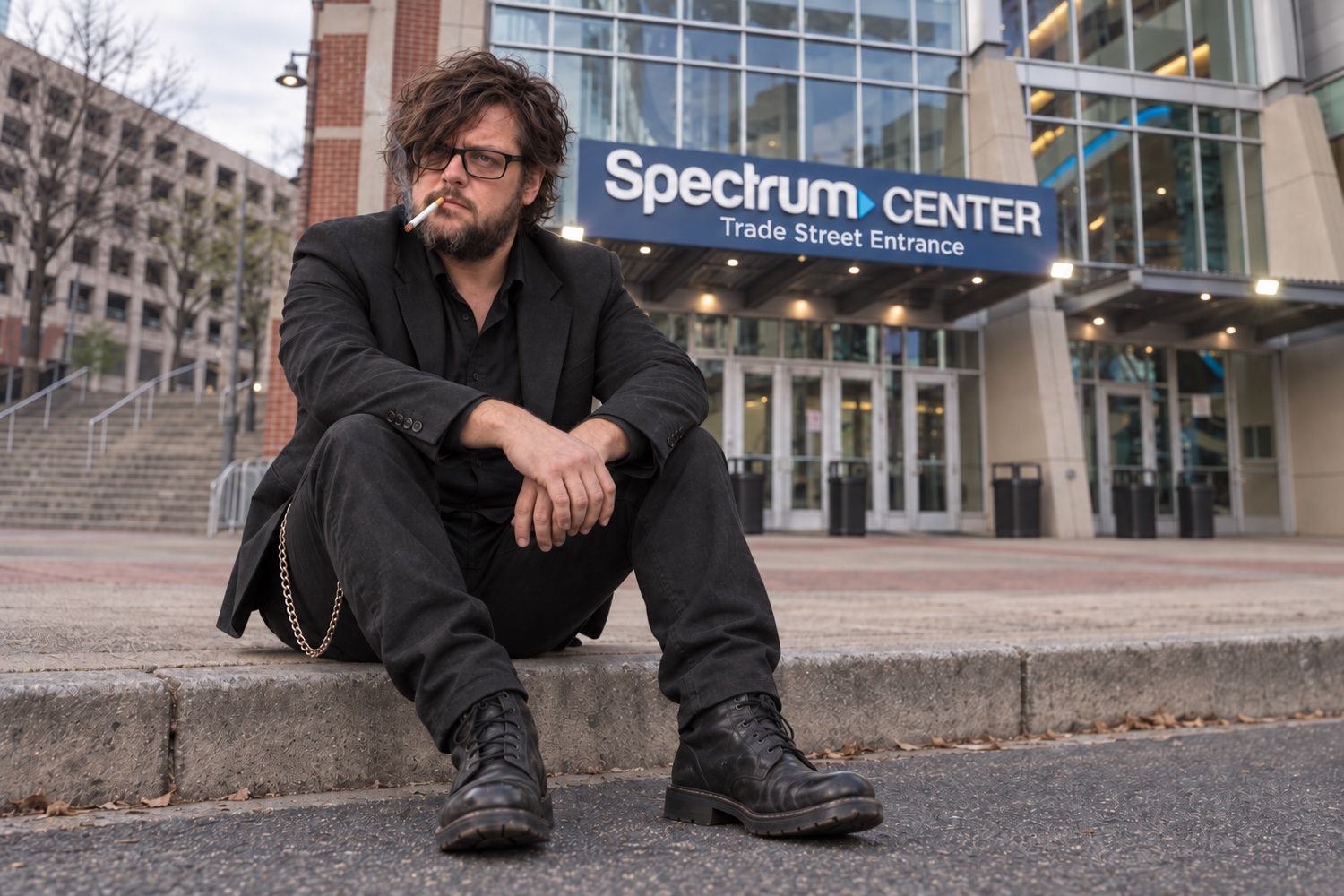 An artist portrait of Chain Wallace seated on a curb outside Charlotte's Spectrum Center, wearing a black suit, boots and wallet chain